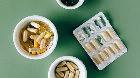 Gélules et poudres de compléments alimentaires dans des bols, choix d'un complément contre l'arthrose